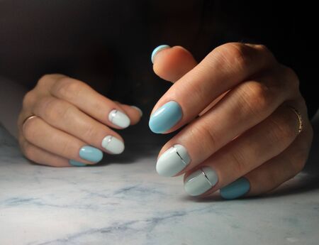 Pale blue coating of short nails with a whitish tint and silver stripe designの写真素材