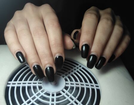 Women's pens with perfect worn manicure on re-processing. Regrown black gel polish without chips. ...