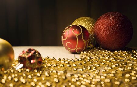 Christmas toys gold and red with gold beads on the table. Red ball with gold pattern. New year's...