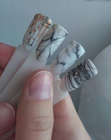 Beautiful abstract designs on the tips. Drawings of cobwebs and marble in black and white on the background of the master's desktop.の写真素材