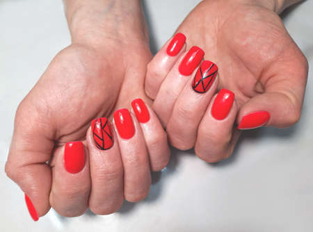 Women's square nails with red gel polish and black stripes design. Red nails with a geometric pattern.の写真素材