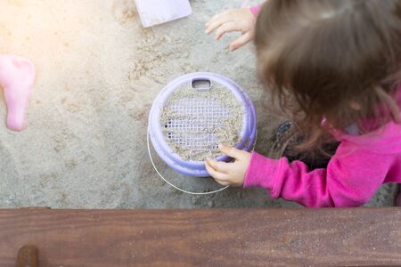 The child is playing in the sandbox