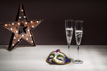 Champagne in glasses and a carnival maskの写真素材