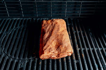 slow grilling of ribs with bacon on the grillの写真素材