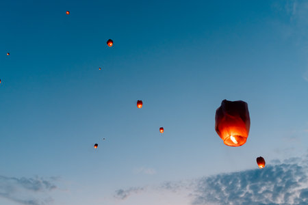 releasing chinese flying lanterns at dusk