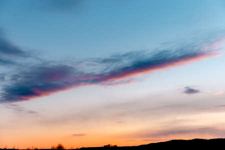 wispy clouds against the sky during sunsetの写真素材