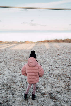 the girl is walking on the beach in winterの写真素材