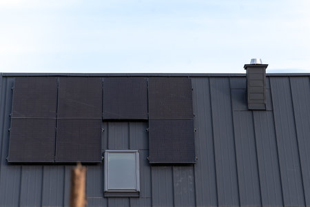 Installation of photovoltaic panels on the roof of a new houseの写真素材