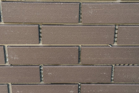 laying clinker tile on the facade of the houseの写真素材