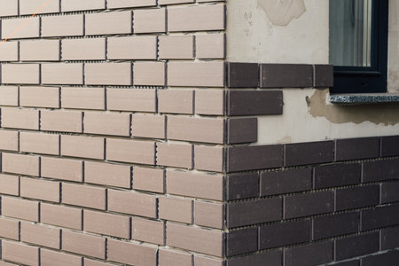 laying clinker tile on the facade of the houseの写真素材