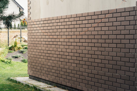 laying clinker tile on the facade of the houseの写真素材