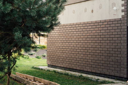 laying clinker tile on the facade of the houseの写真素材