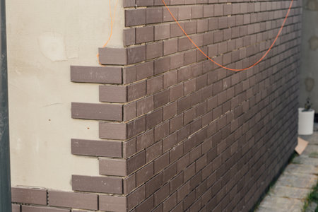 laying clinker tile on the facade of the houseの写真素材