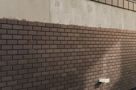 laying clinker tile on the facade of the houseの写真素材
