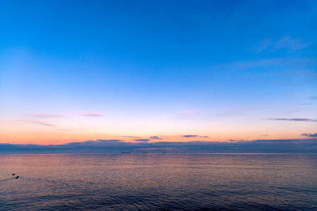 the setting sun in Gdynia behind the sea horizonの写真素材