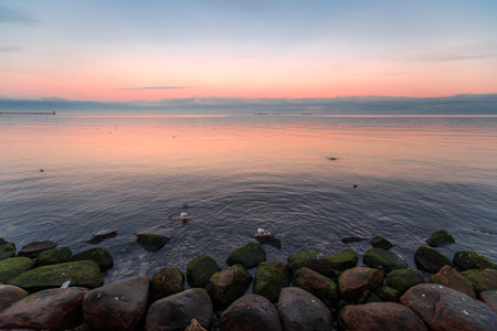 the setting sun in Gdynia behind the sea horizonの写真素材