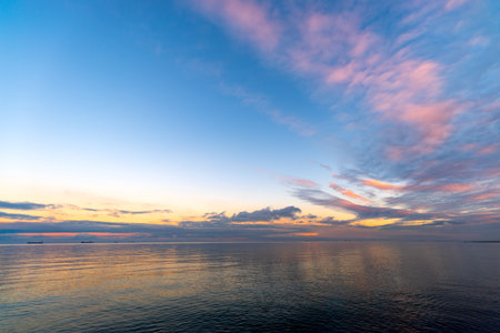 the setting sun in Gdynia behind the sea horizonの写真素材