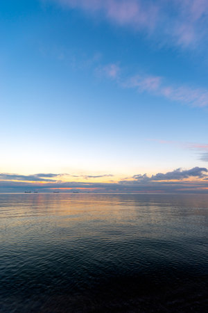 the setting sun in Gdynia behind the sea horizonの写真素材