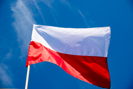 Polish flag against a blue sky backgroundの写真素材