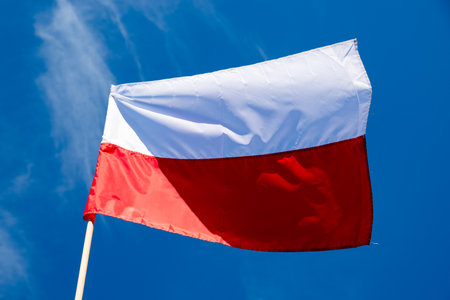 Polish flag against a blue sky backgroundの写真素材