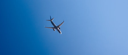 flying plane against the blue skyの写真素材