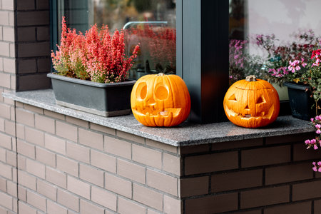decorative pumpkin carved for Halloween in front of the houseの写真素材