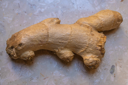 The ginger root closeup on the marble background