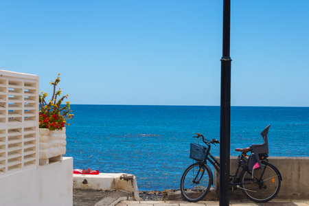 Ocean view with the bicycle with baby seat, flowers and towel with the shoe on it - Imageの写真素材