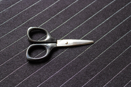 Black scissors on the striped dark fabric background - Imageの写真素材