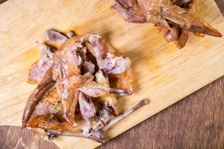 remains of chicken, bones lie on wings on wooden boardの写真素材