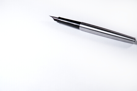 On a blank sheet of paper lies an ink handle metalの写真素材