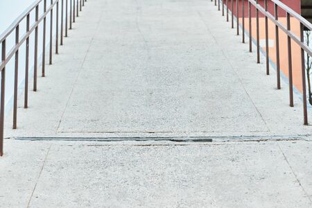 road going up is fenced with metal handrails with a railing