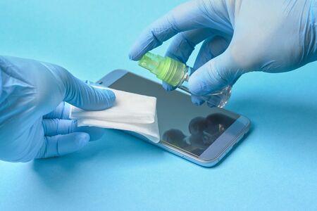 smartphone sanitizer disinfection. virus protection. blue background