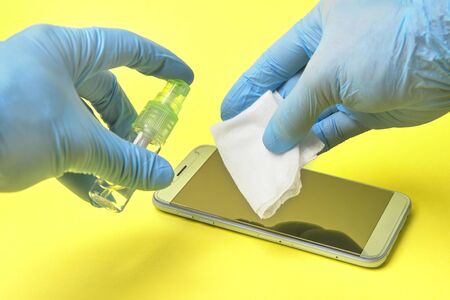 smartphone sanitizer disinfection. virus protection. yellow background