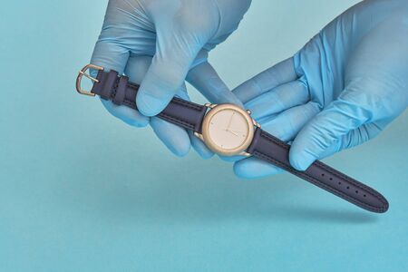 doctor in rubber gloves holds a clock. time care concept