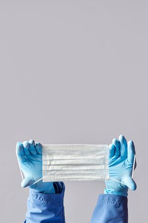 doctor holds a medical mask in his hands. the concept. copy spaceの写真素材