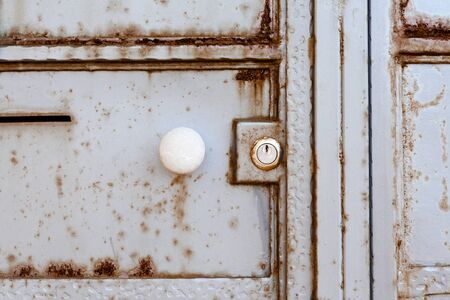 door handle and lock on an old rusty metal door. fence. the background. textureの写真素材