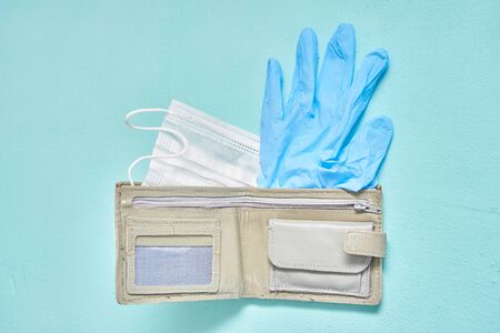 medical mask leather wallet and blue latex glove. virus and economics concept
