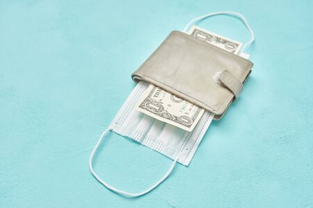 medical protective mask in a leather wallet and one dollar. economy and epidemic concept