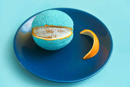 painted orange in blue on a plate. peeled slice of peelの写真素材