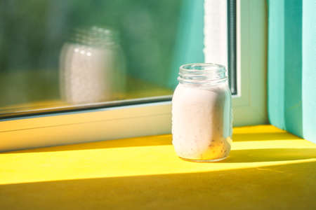 Strawberry smoothie glass on a windowsill near the window. concept healthy eating, freshness, summerの写真素材