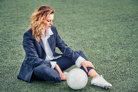 portrait of a beautiful woman football player in a strict office suit, concept sports office manager leisureの写真素材
