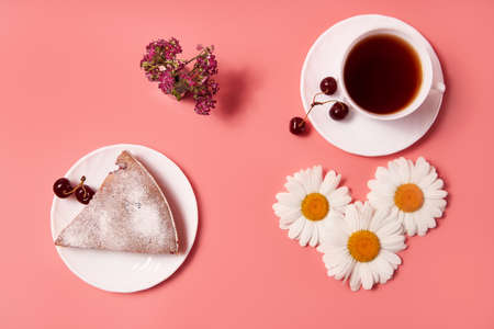 piece of cherry pie on a plate with tea in a white mug. pink backgroundの写真素材