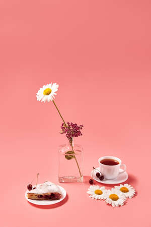 piece of cherry pie on a plate with tea in a white mug. pink backgroundの写真素材