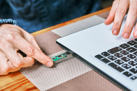 man connects usb flash drive with laptopの写真素材