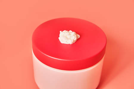 pink jar with drop of cream on the lidの写真素材