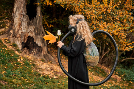 little girl with white rose in the hands of hay. child in gas mask with breathing apparatus backpack...