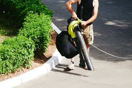 worker blows dust off the asphaltの写真素材