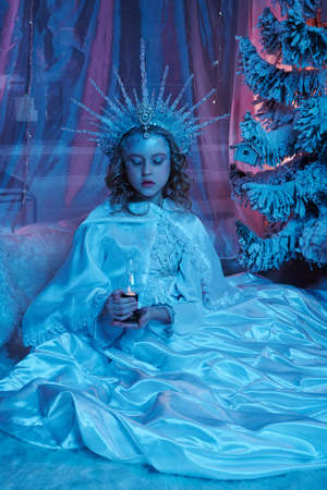 snow fairy in the forest holds a lamp with fire in her hands. fabulous decoration