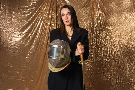 glamorous woman fencer with helmet and epee